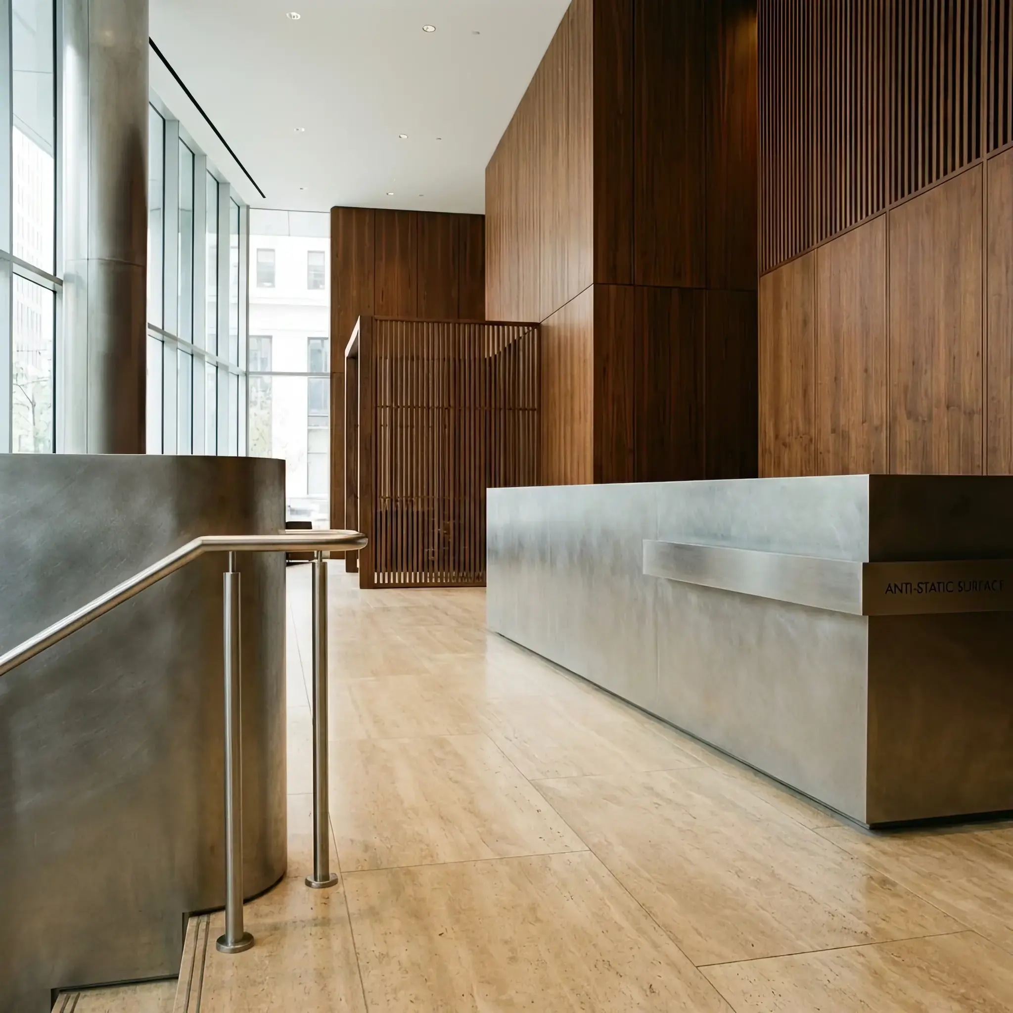 Архитектура и дизайн: Стойка приемная с зеркальным покрытием 'жидкий металл', отражающая интерьер вестибюль